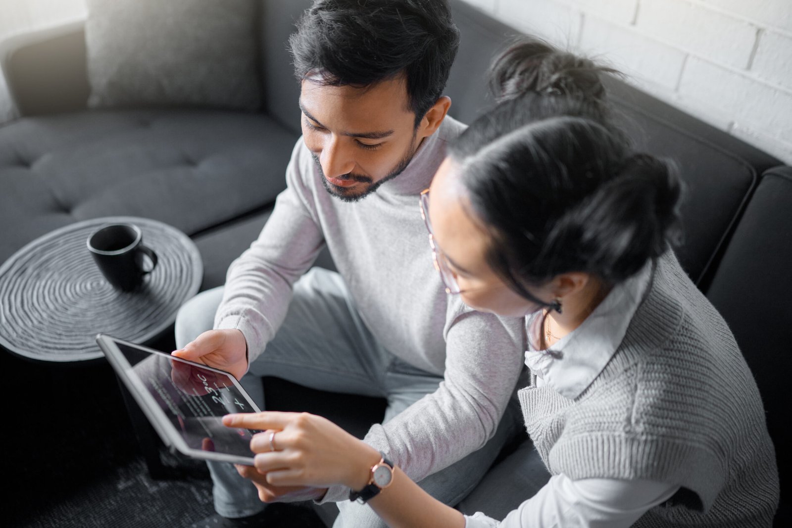 Tablet, sofa and couple with smart home technology for thermostat heating, apartment security network or house automation. AI software, digital app monitor and people with interactive IOT electronics